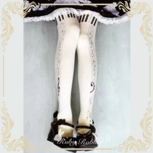 Milk white piano keyboard lolita tights detailed close-up overhead perspective showing complete musical notation and clef pattern prints worn with black lace lolita skirt