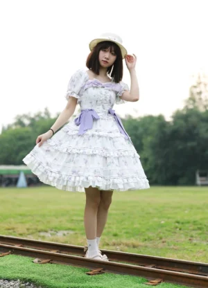 Milky white floral print classic lolita OP dress side front view model wearing short black hair straw hat railway track scenic outdoor setting