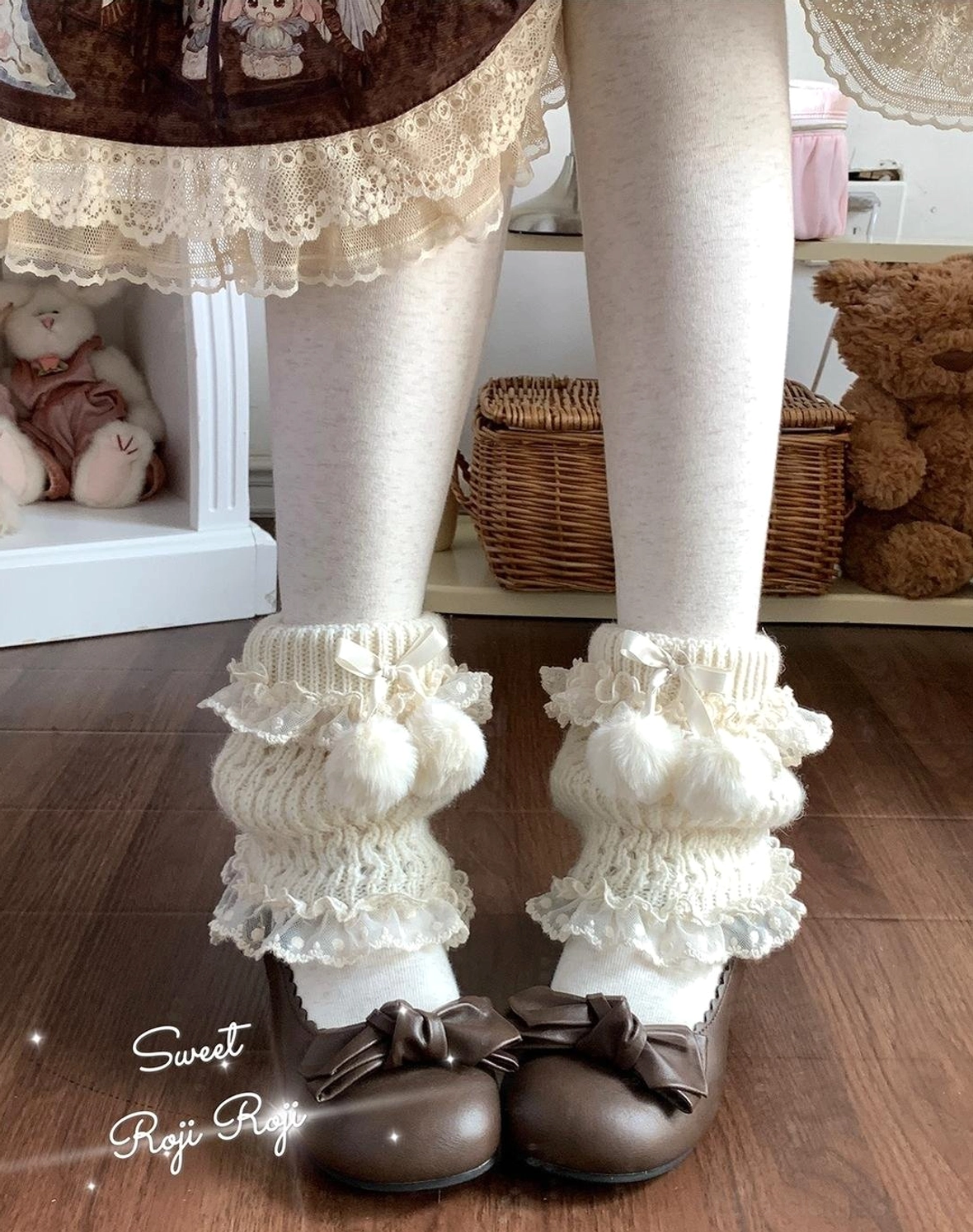 Milky white lolita leg warmers worn on model legs with white opaque tights and brown bow loafers, showing fuzzy pom-pom details and ruffled lace cuffs