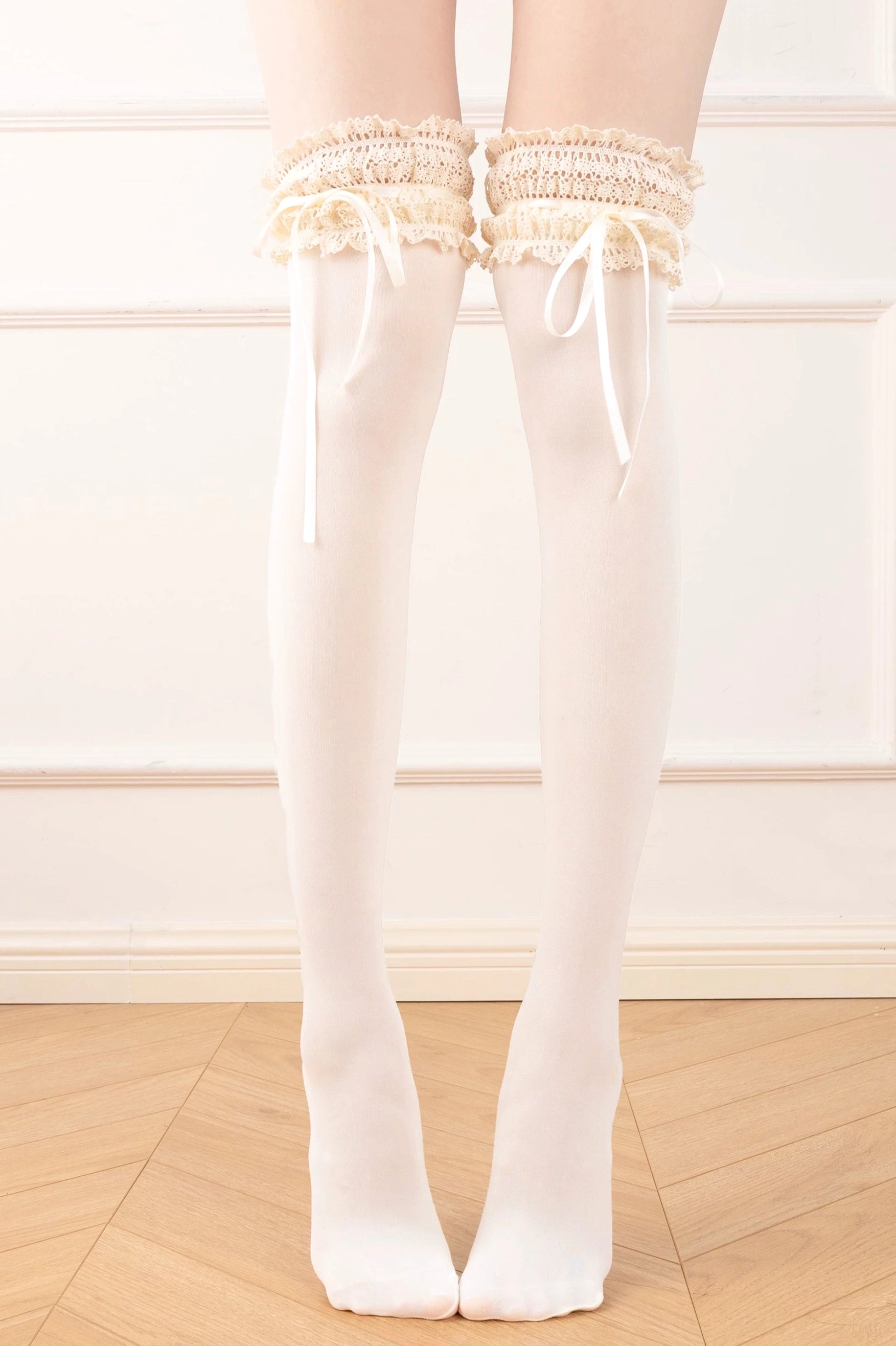 Milky white over-the-knee classic lolita ruffle socks featuring light cream frilled lace thigh cuff and satin ribbon bow, extended leg view