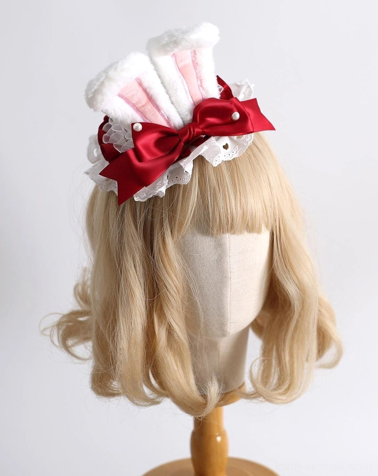 Compact mini sweet lolita bunny ear hair accessory with pink inner fur ears, red satin bow with pearl accent, and lace trim on display mannequin side angle view
