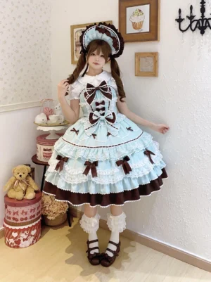 Front full-body portrait of mint blue and chocolate brown fondant dream sweet lolita jsk dress with tiered ruffled skirt, brown decorative bows, contrast brown hemline, paired with white frilled socks and brown Mary Jane shoes