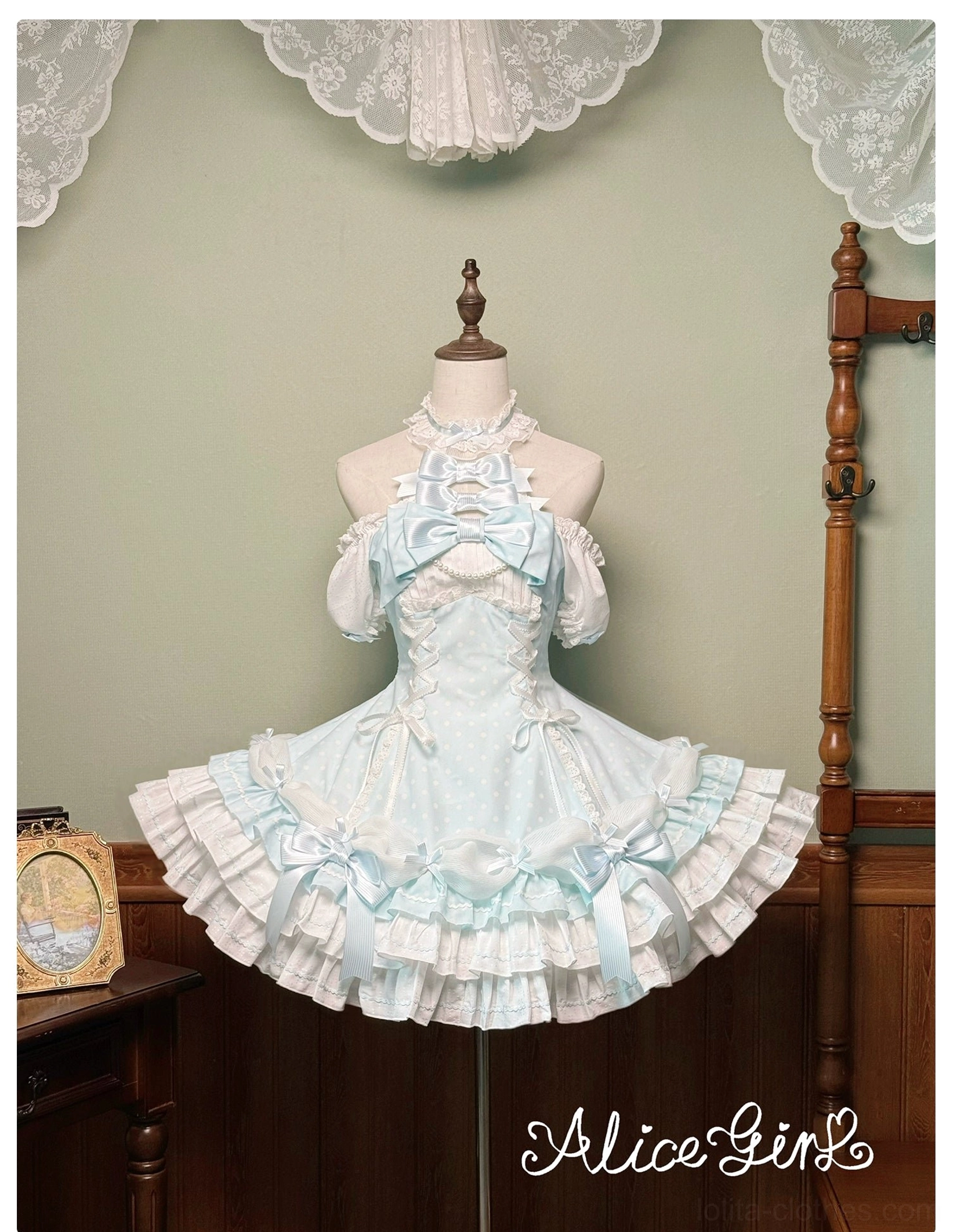 Mint blue polka dot Lolita halter OP dress front view on mannequin with ruffled skirt and chest bow accent vintage studio