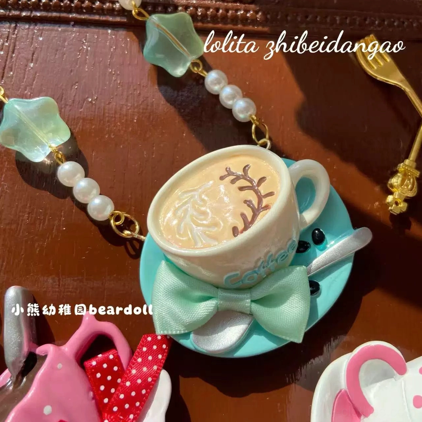 Mint green Lolita necklace featuring realistic latte art on ceramic coffee cup pendant with mint green bow and decorative bead chain in close-up overhead view