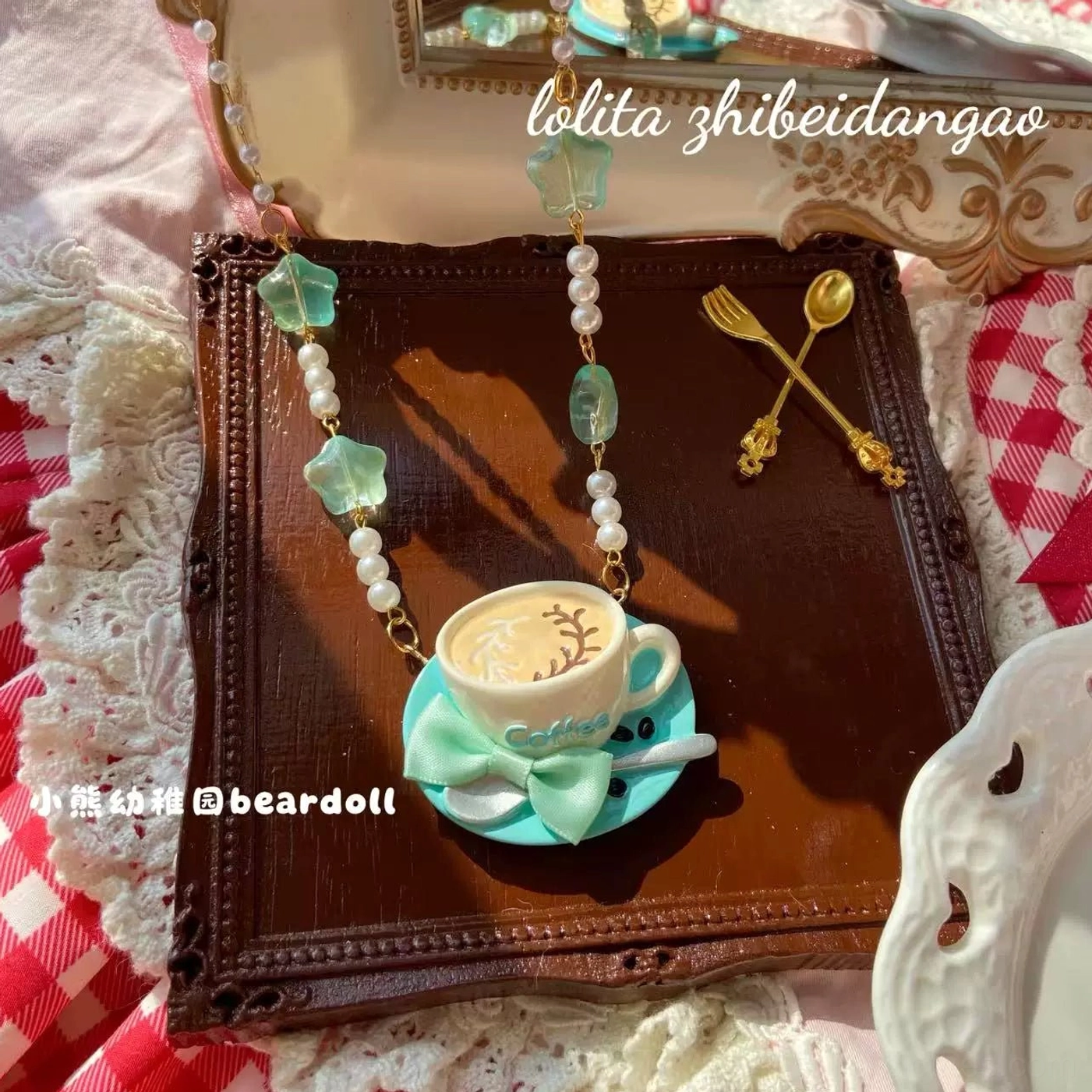 Mint green Old School Lolita coffee cup necklace with latte art pendant decorated with geometric green beads and faux pearls on dark wooden tray