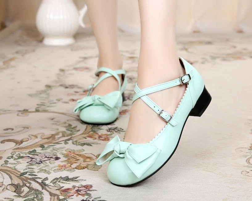 Mint green bow cross-strap lolita leather shoes front three-quarter angle model vintage floral background