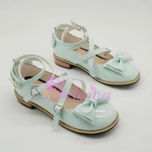 Mint green glossy patent leather lolita tea party Mary Jane shoes with round toe, dual ankle buckle straps, and decorative bow ornament - flat lay three-quarter front view