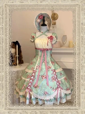 Mint green old school lolita OP dress with floral print, square neckline, short puff sleeves, pink ribbon lacing, ruffled lace hem, front full-body view in vintage lace-framed indoor setting with matching floral bonnet