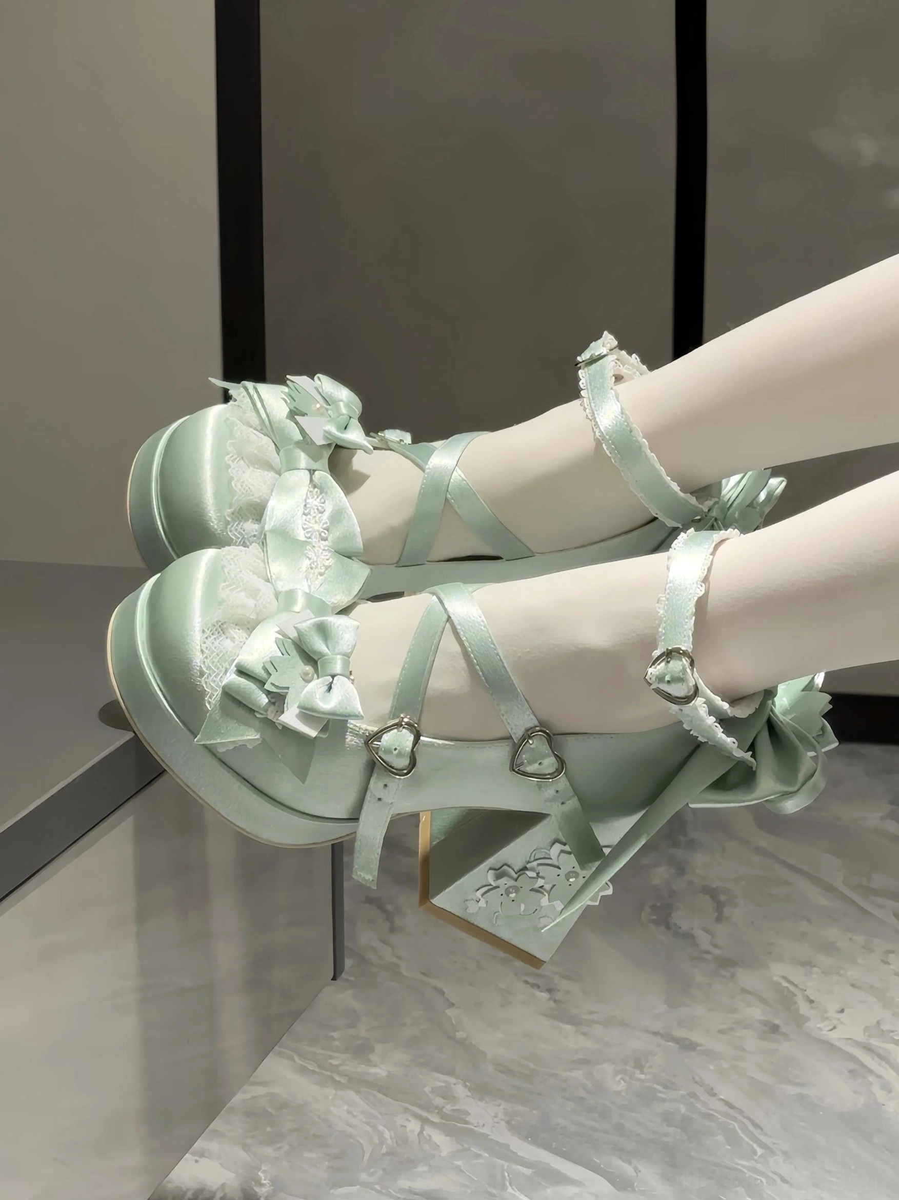 Mint green sweet lolita chunky platform heel shoes with ruffled lace trims cross ankle straps large back bow and chunky block heel on mannequin legs side view