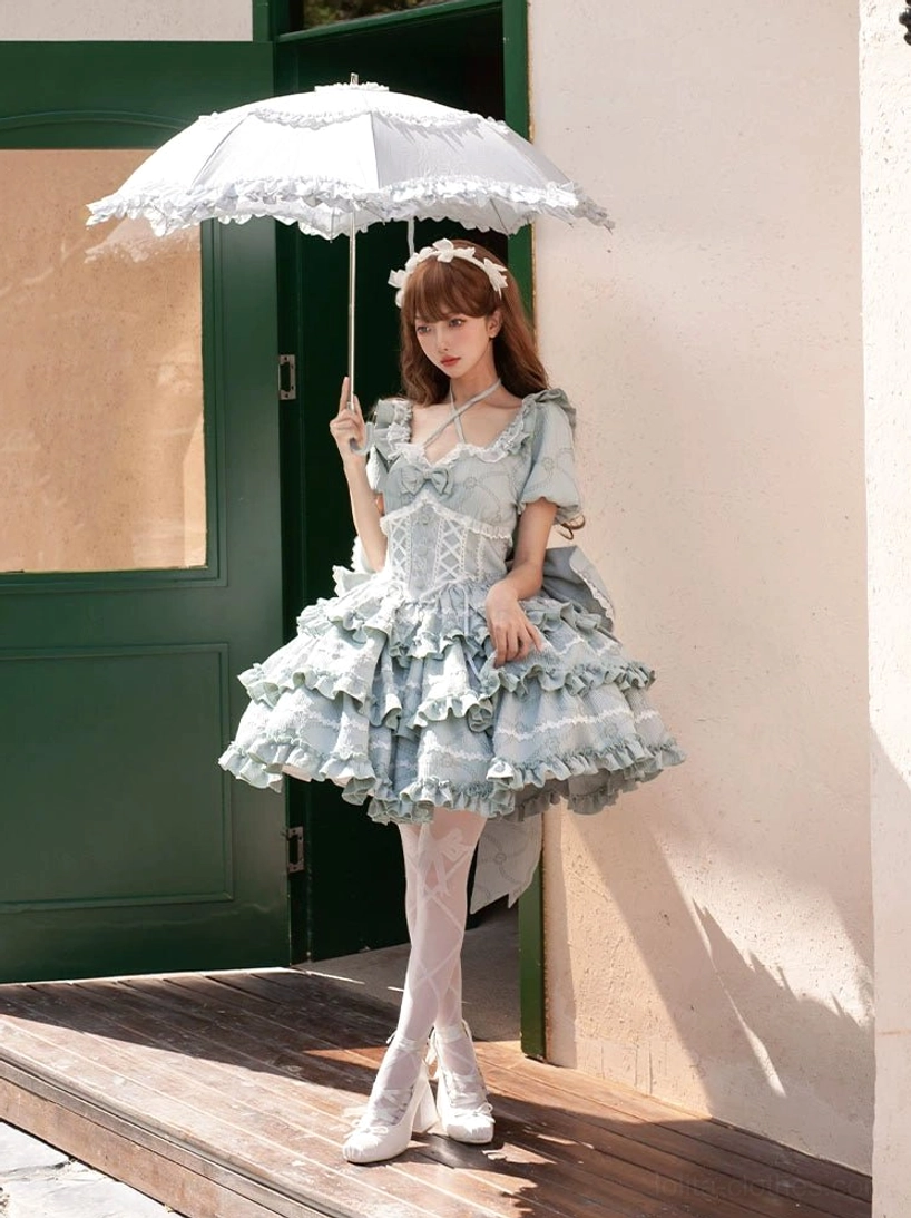 Mint green sweet lolita OP dress full front view wooden doorway corset bodice jacquard layered ruffle skirt parasol