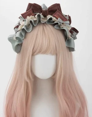 Mint green satin ruffled lolita hair KC headband with large brown bows and beige lace edging styled on blonde wig mannequin
