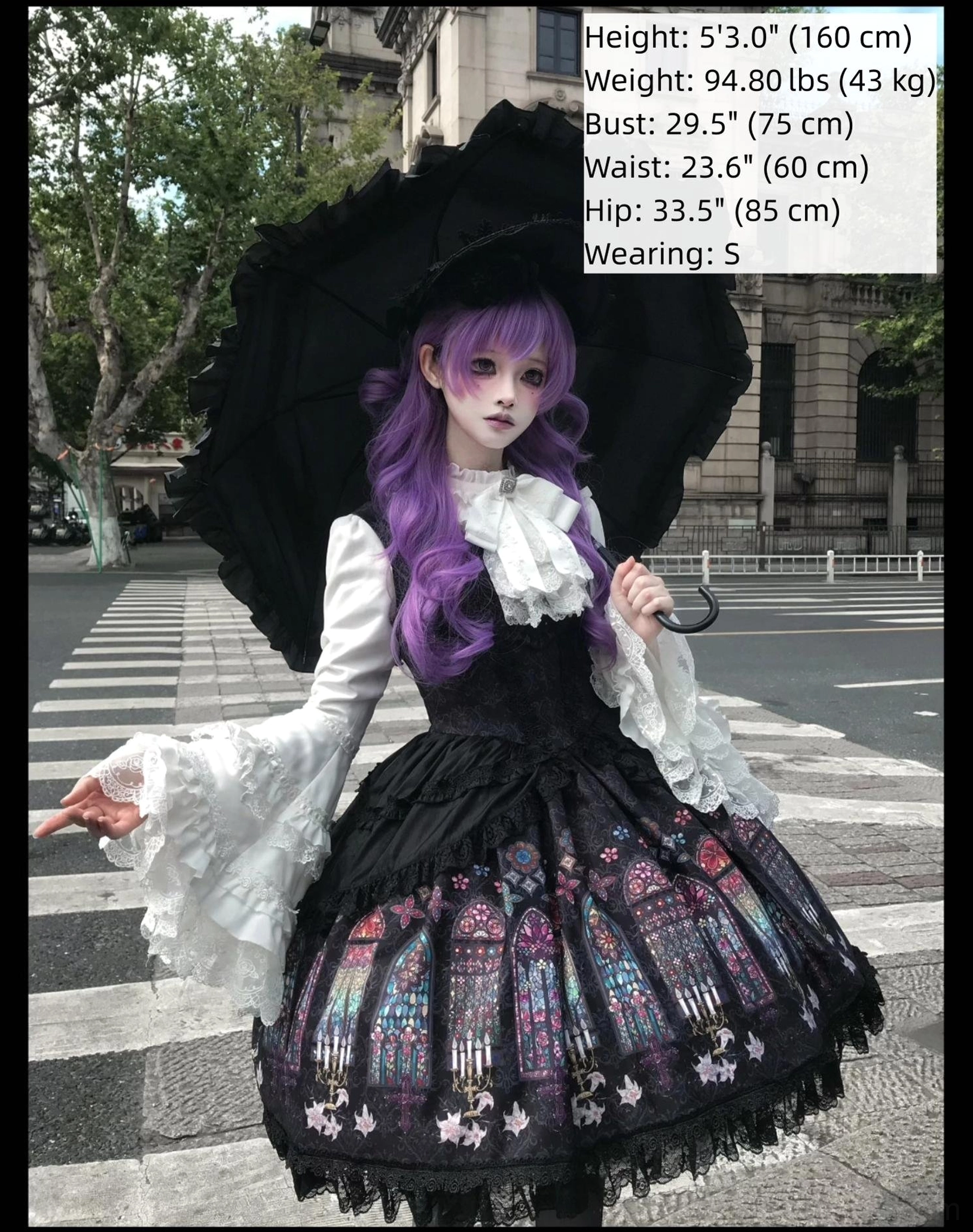 Model wearing black gothic lolita stained glass print dress white ruffled trumpet sleeves outdoor street crosswalk portrait