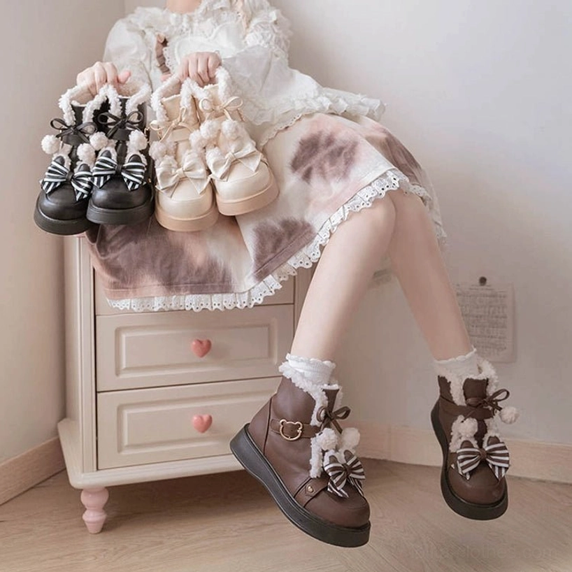 Model wearing frilly lolita dress holding winter fleece snow boots indoor lifestyle shot bedroom nightstand setting chunky sole platform design