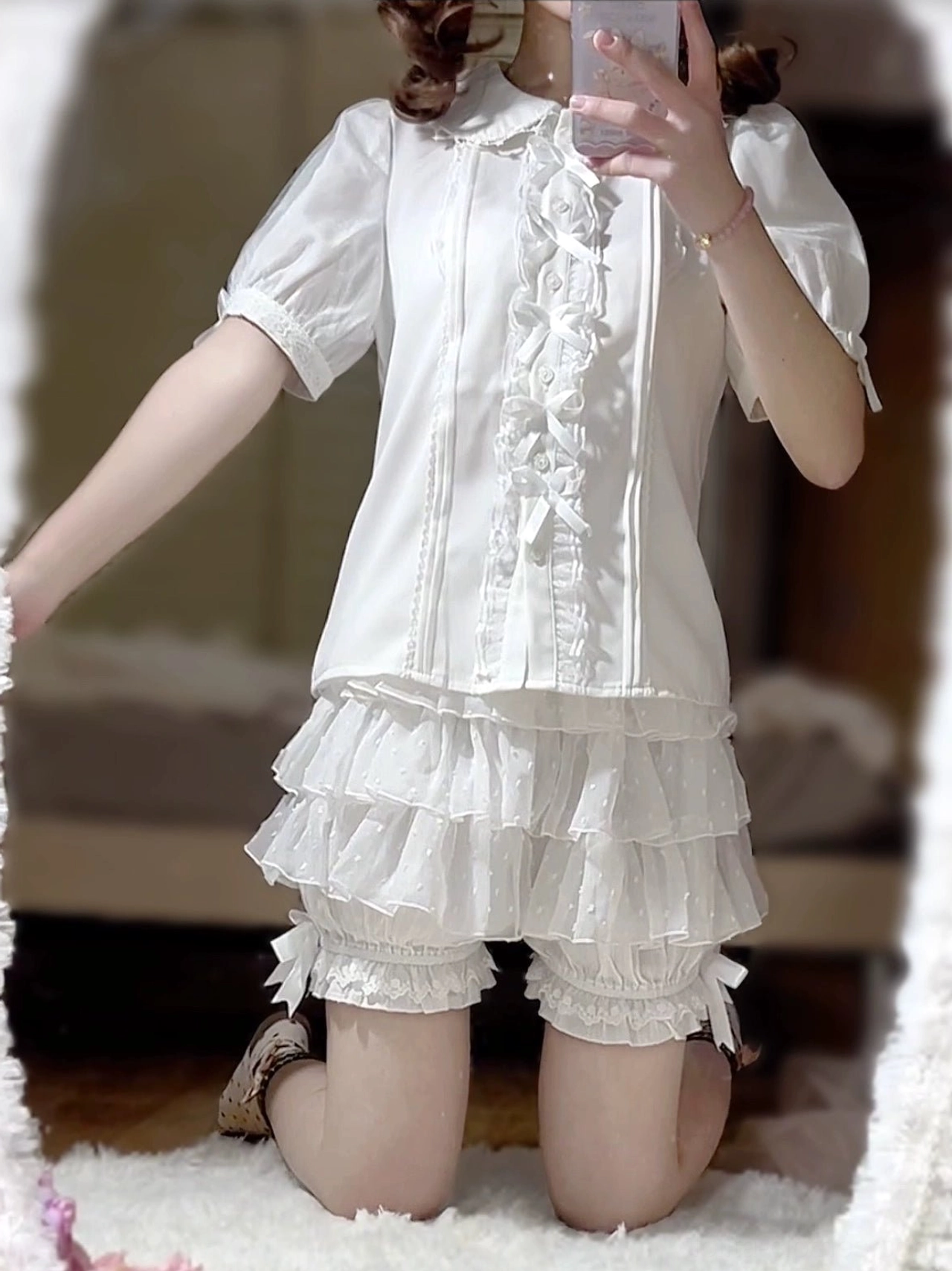 Side-front view of model wearing layered white lolita bloomers with neat ruffled silhouette under lolita shirt in home mirror selfie