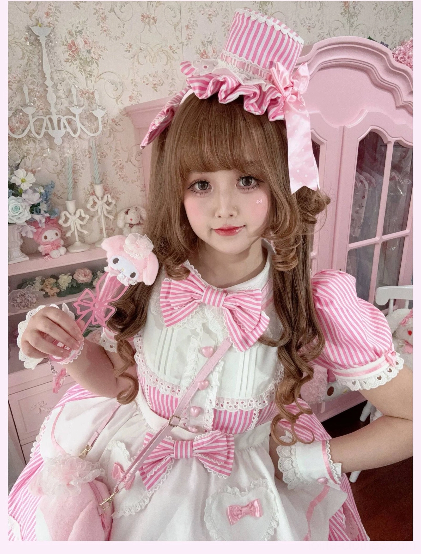 Model sitting in pink striped lolita OP dress showing comfort and wearability for extended events