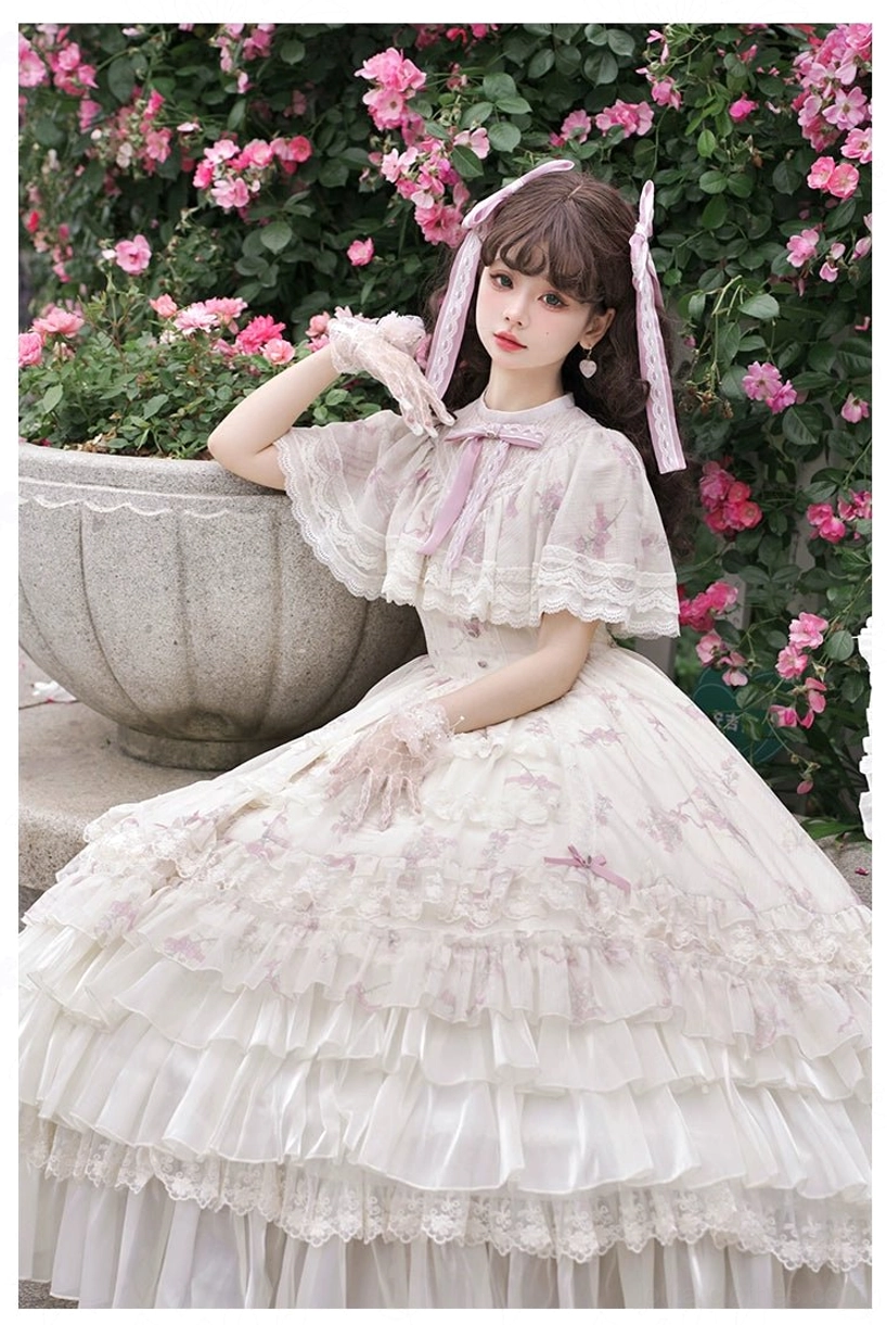Classic lolita OP dress side sitting view high stand collar capelet sleeves full ruffled skirt lace trim rose garden backdrop