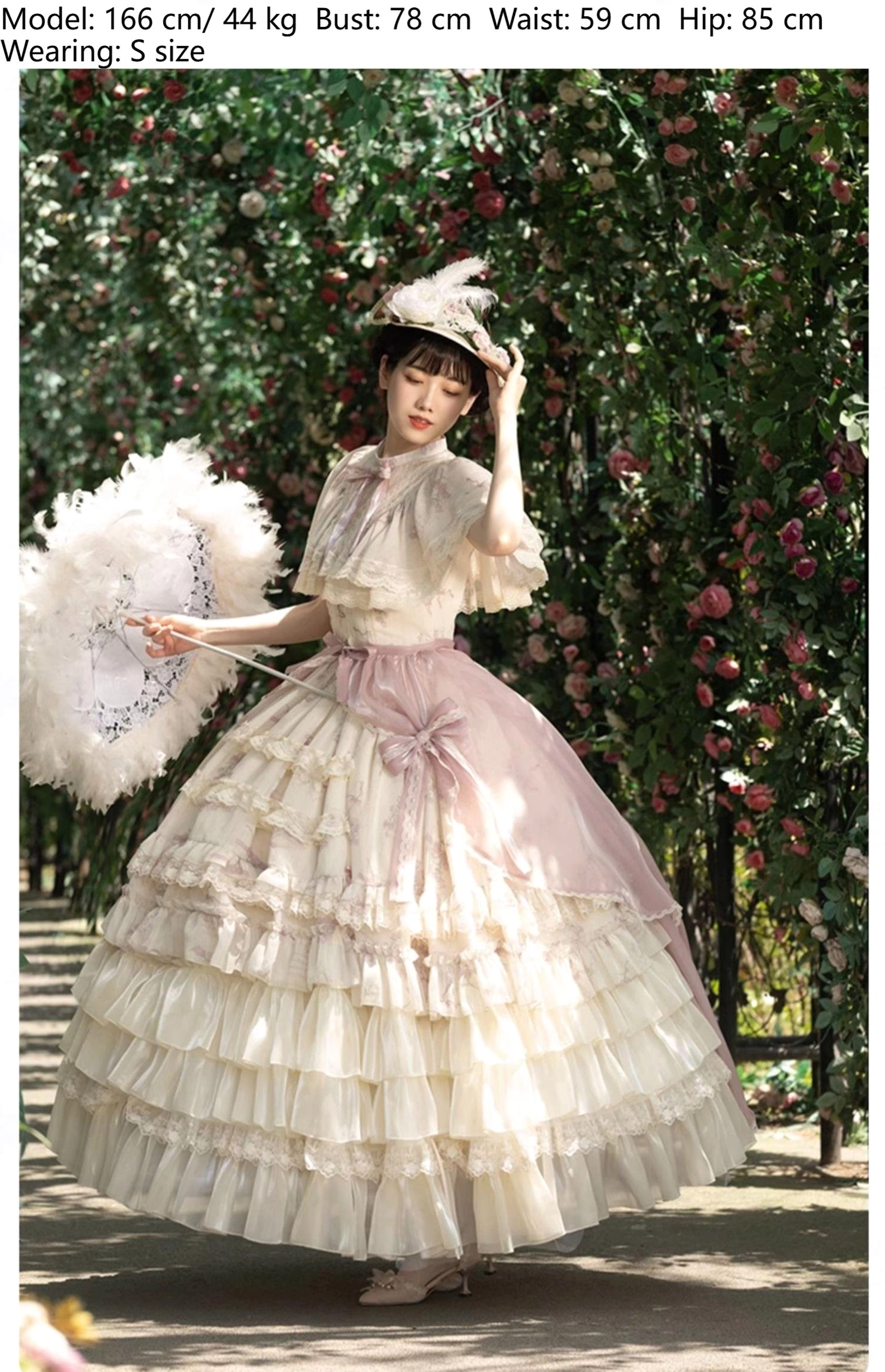Edwardian collar lolita OP dress three-quarter front garden path cream base light pink floral prints pink waist sash multi-tiered ruffled skirt model