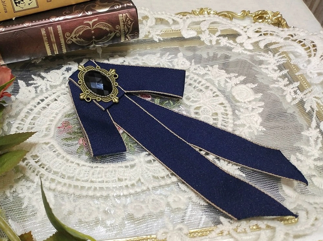navy-blue-lolita-ribbon-bow-brooch-gold-edge-trim-oval-black-gemstone-bronze-setting-white-lace-doily-green-leaves-vintage-styling