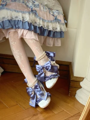 Navy blue detachable bow classic Lolita wedding heels with ruffled lace trim worn with blue-white Lolita dress and floral stockings on wooden floor