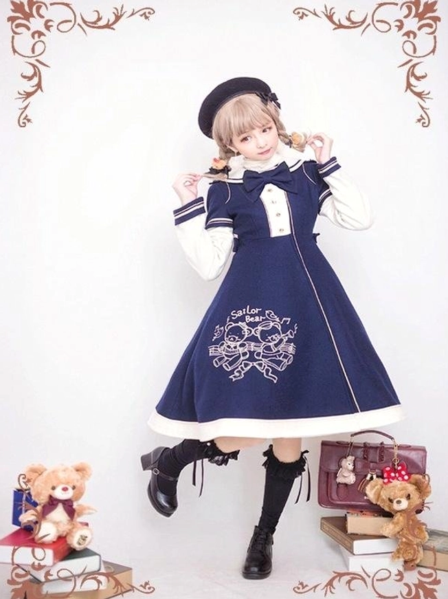 Navy blue sailor lolita winter overcoat with white contrast cuffs and trim, red bow tie on sailor collar, cute bear embroidery detail on skirt, dynamic pose with lifted leg
