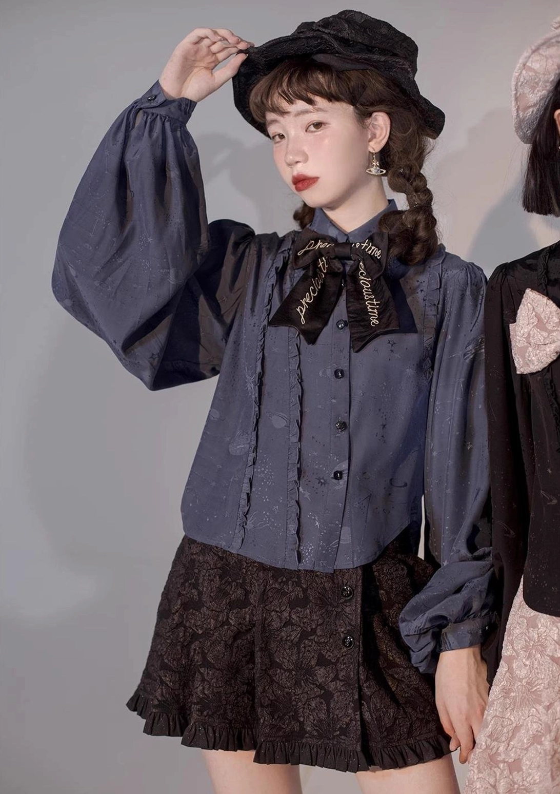 Navy blue Lolita blouse half-body close-up front view on model wearing black ruffled skirt and bow tie showing elegant retro styling vintage charm