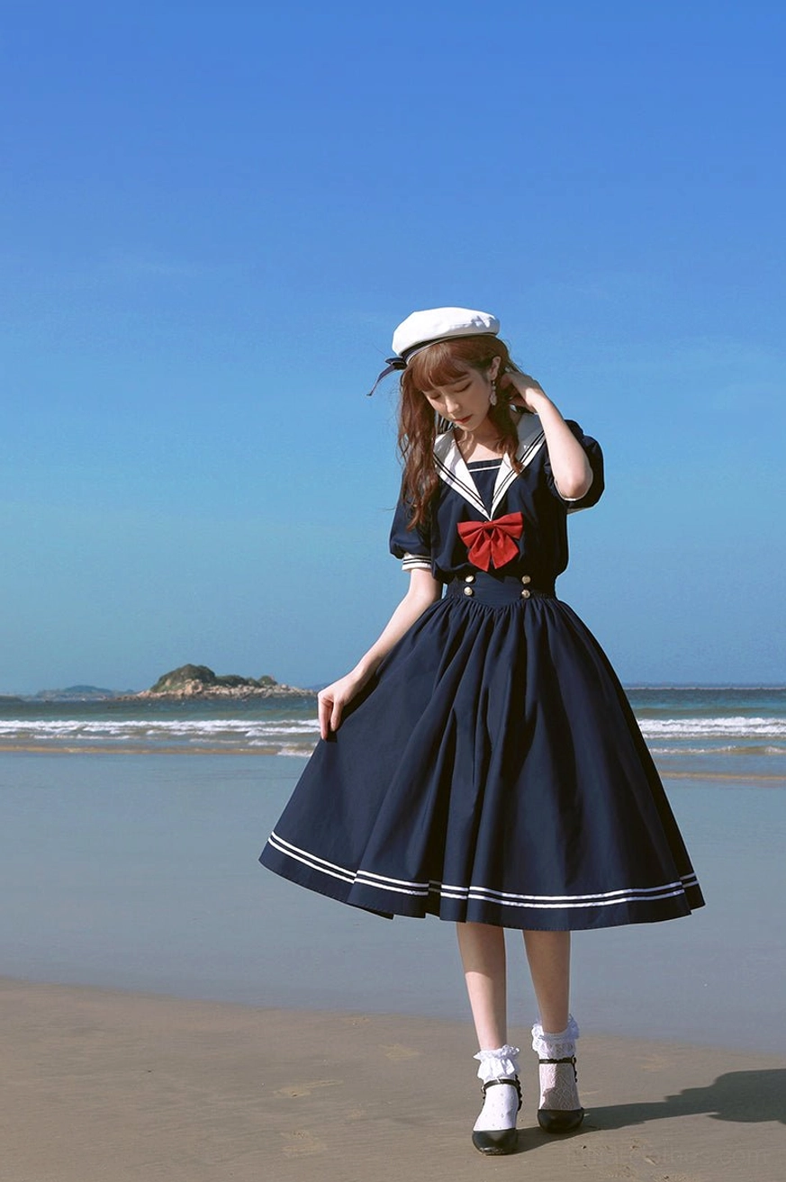 Navy blue sailor lolita OP dress full body front walking view female model sailor hat coastal beach stripe trim details lolita