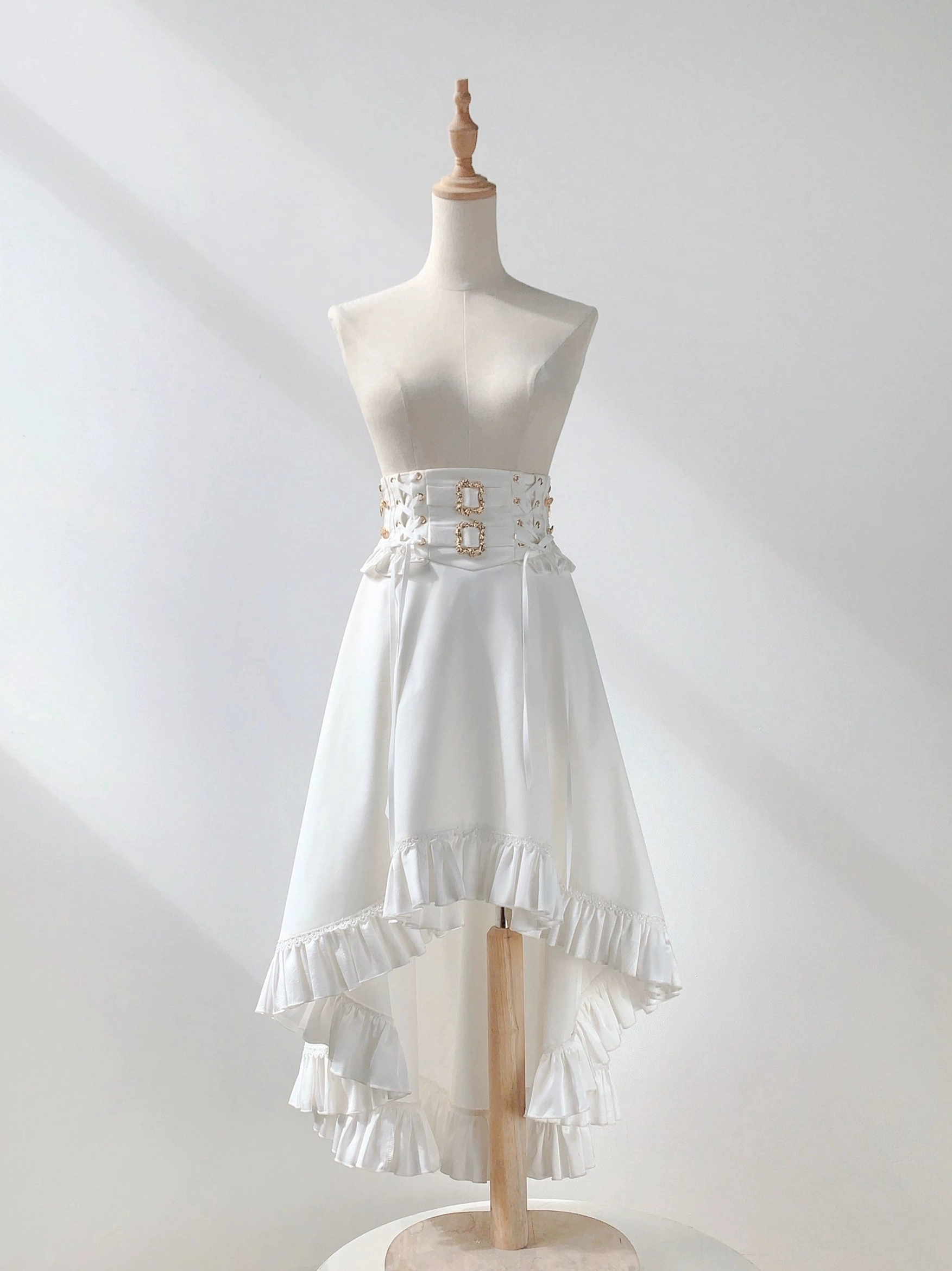 High-waist white high-low ruffled ouji lolita skirt asymmetric hem corset-style waist belt decorative buckles flat display dress form