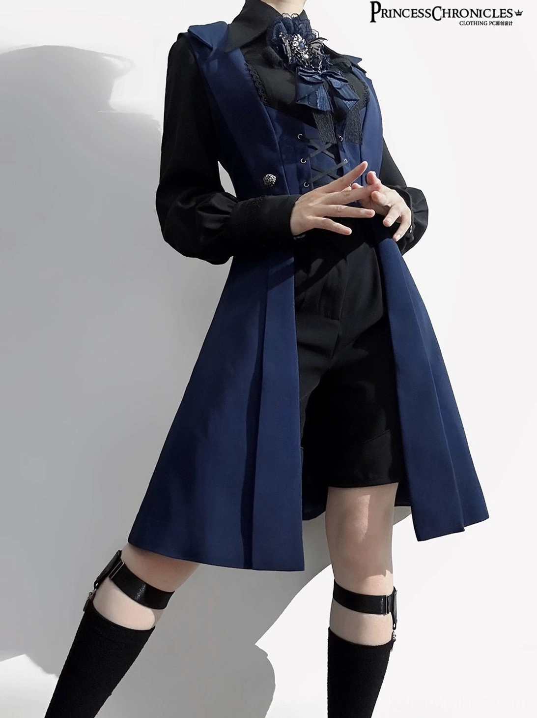 Night Prelude Gothic Ouji Lolita vest close-up detail of upper outfit showing elaborate ruffled ascot with metal brooch, intricate lace-up vest front, silver buttons, and tailored navy coat hem