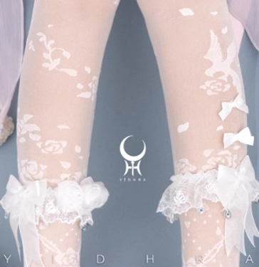 Close-up overhead shot of beige Lolita sheer tights with white bird and floral stereo patterns, ruffled lace ankle cuffs adorned with bows and fluffy trim, product-focused display with brand background