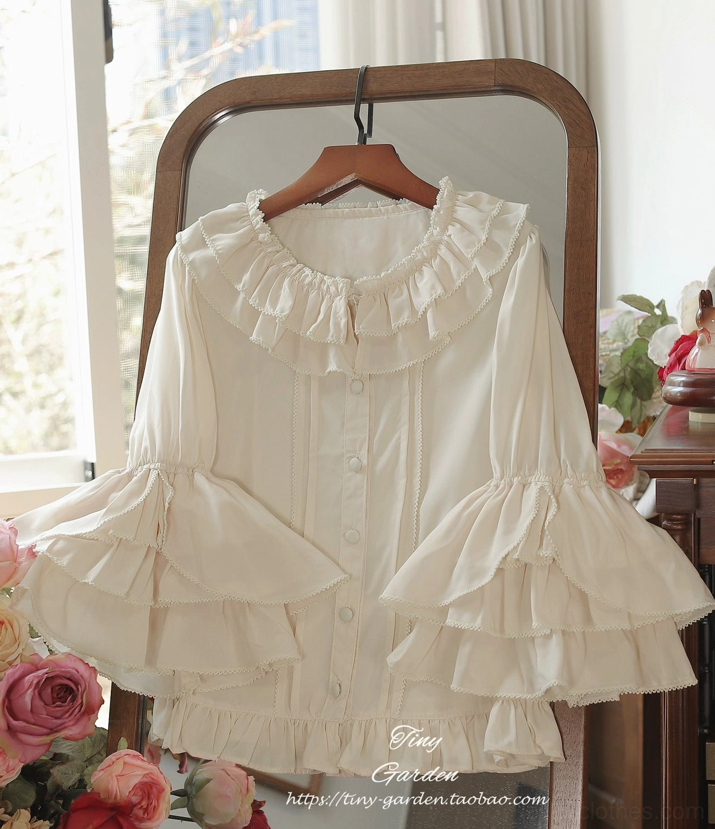 Off-white vintage ruffled lolita blouse with double-layered ruffled collar and multi-layered bell sleeves, hanging front display with retro mirror and flower background, detailed vintage aesthetic