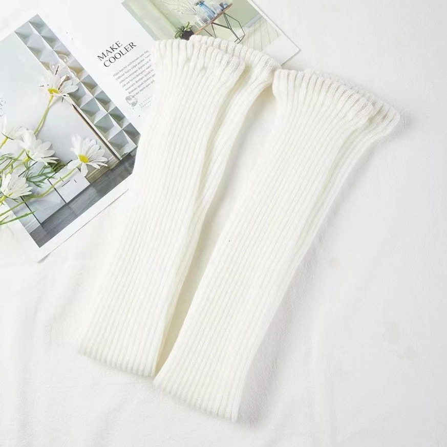 Pair off-white knitted lolita leg warmers flat lay display vertical ribbed knit texture fashion magazine flowers