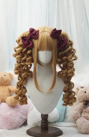 Golden brown old school lolita wig with voluminous spiral ringlet pigtails, blunt see-through bangs, and dark red flower clips on display mannequin with plush backdrop