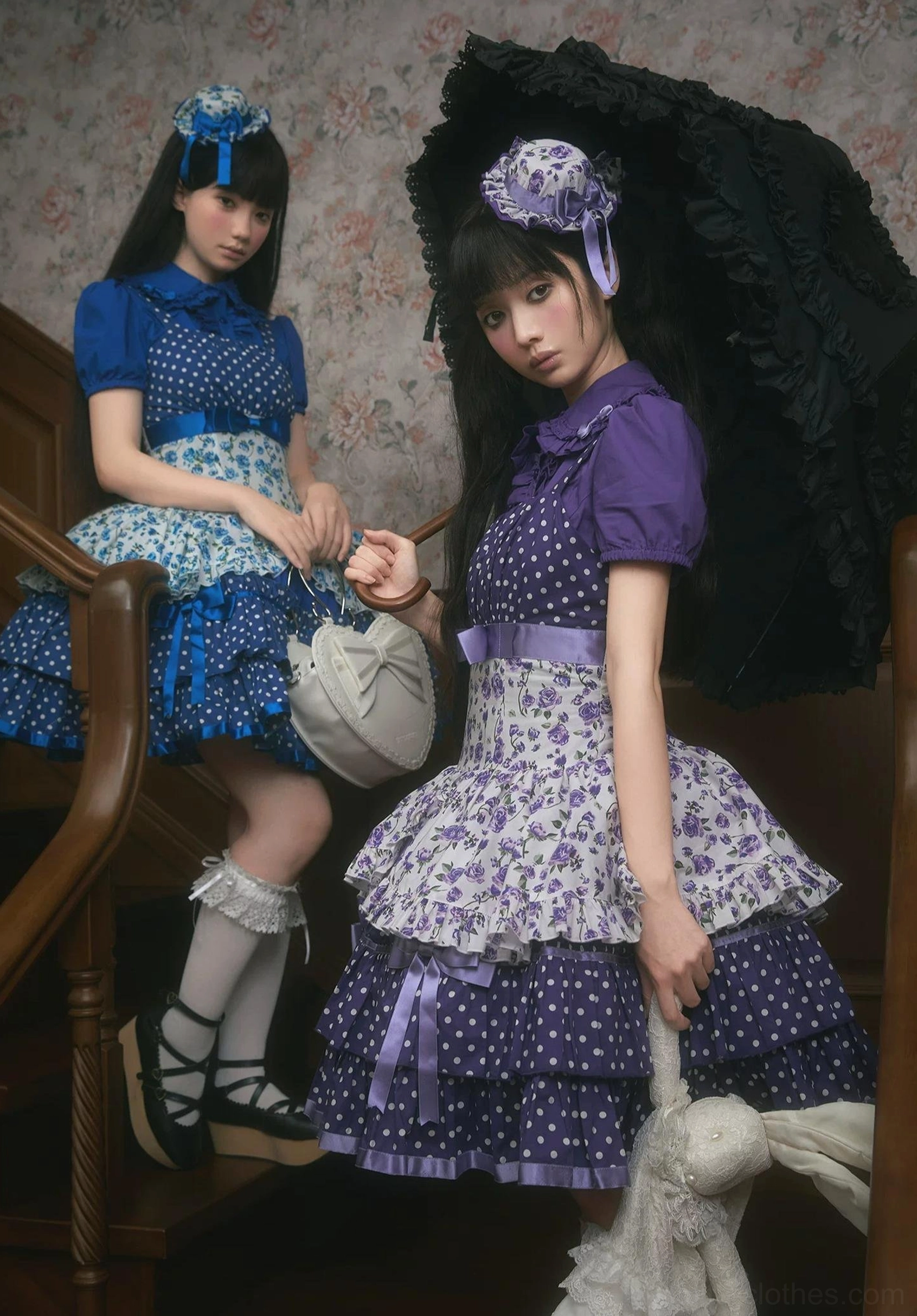 Coordinated blue and purple old school Lolita JSK dresses with vintage room styling, half-body indoor group view featuring round vintage handbag, lace parasol prop, and matching color-coordinated accessories