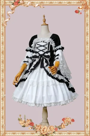 Classic old-school lolita OP dress with patchwork puff sleeves featuring black and white color-blocking, displayed on wooden dress mannequin against vintage floral border background, three-quarter front view showing crisscross lace-up front and large waist bow