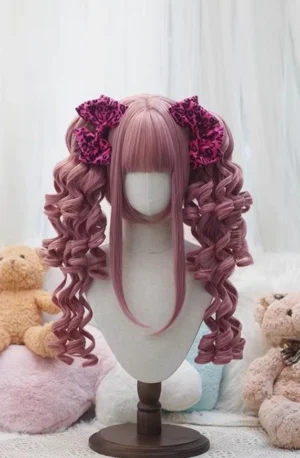 Dusty rose pink old school lolita wig with voluminous spiral ringlet twin ponytails, see-through bangs, and dark red flower hair clips displayed on mannequin with teddy bear backdrop