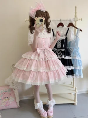 Pink sugar-sweet old school lolita JSK dress with multi-layer lace tiered skirt, large front bow, corset-style bodice, full-body selfie with pink cat ear headbow and fluffy loafers