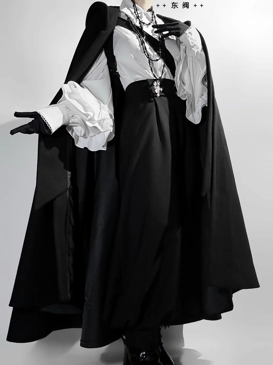 Ouji hooded cape fabric drape and flow detail showing woolen-like texture matte black color and volume