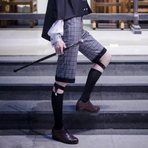 Black Ouji Lolita calf socks with adjustable leather leg garters worn by male model on indoor stairs, paired with vintage Ouji outfit and walking cane, side view showing sock length and garter detail