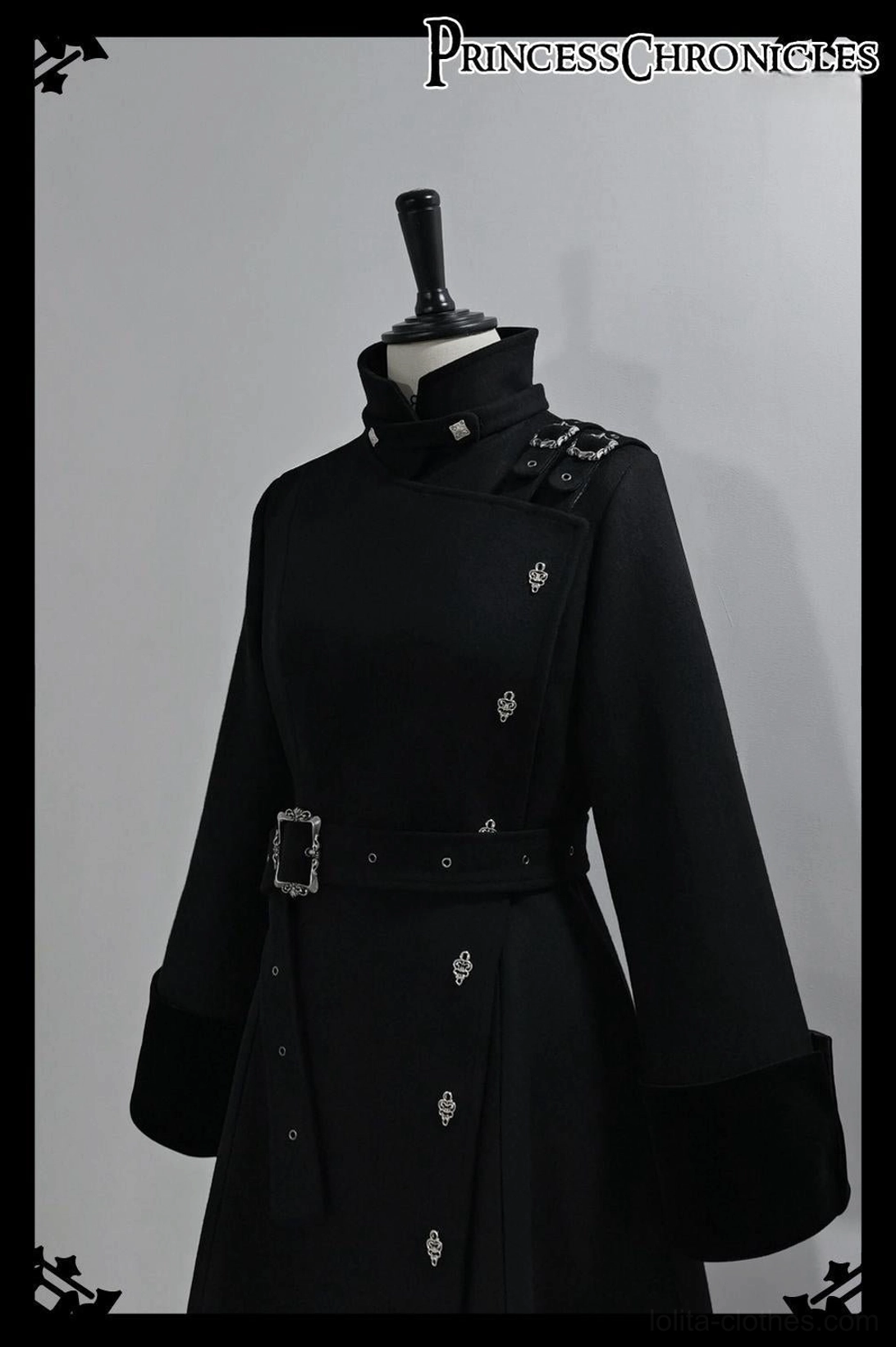 Close-up upper front view of black Ouji Lolita overcoat on dress mannequin featuring high stand collar with adjustable shoulder straps hidden button placket waist belt square buckle metal studs