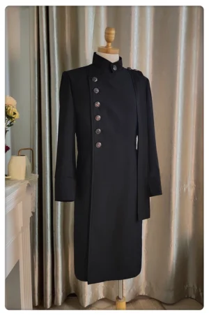 Ouji Lolita black slim long coat three-quarter front angle, asymmetrical button placement and shoulder epaulet decoration visible, tailored fabric texture