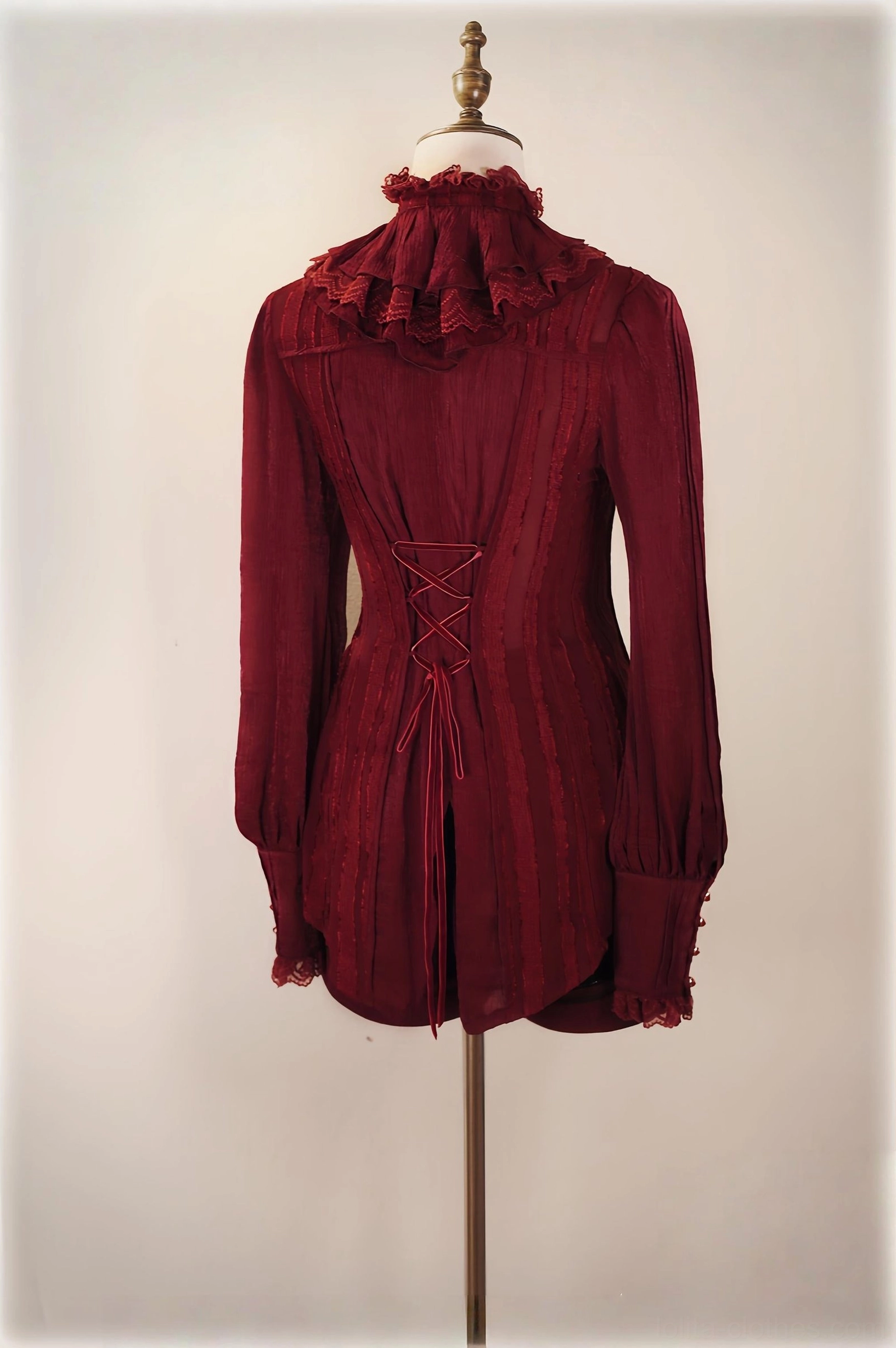Back view of burgundy red Ouji lolita blouse showing corset-style lacing, ruffled stand collar and asymmetrical tail hemline on dress form
