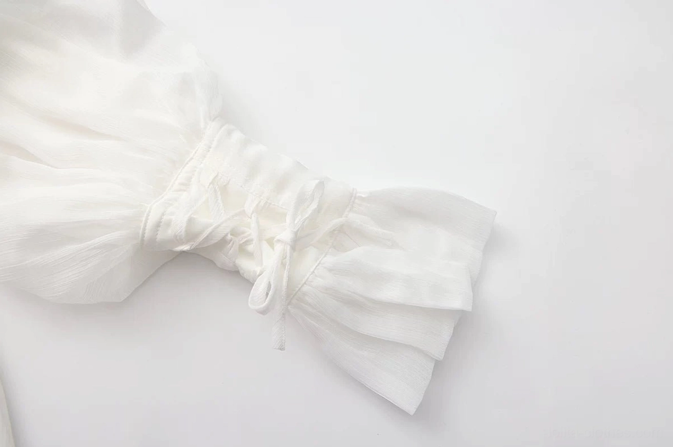 Close-up macro detail of white ouji lolita blouse adjustable drawstring cuff with ruffled flared sleeve end and sheer chiffon material composition, flat lay cuff detail
