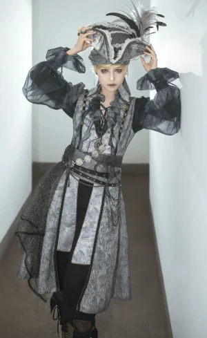 Prince-style pirate ouji lolita blouse costume worn by model in elegant historical indoor portrait setting, sheer ruffled long sleeves and theatrical waist accessories with decorative feathered hat