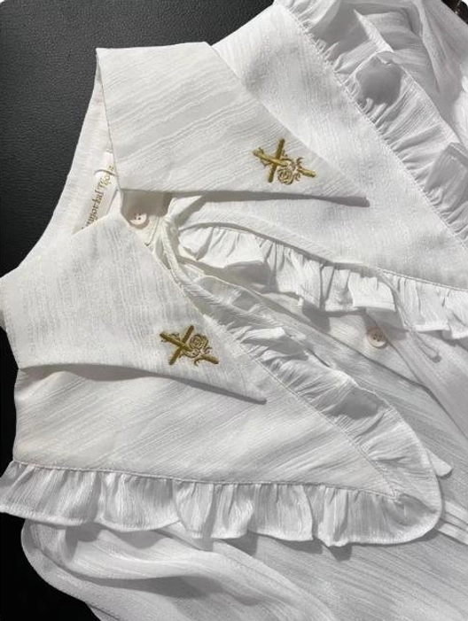 Close-up detail white ouji Lolita blouse striped textured fabric gold brand embroidery collar ruffled trim front button fastening construction quality