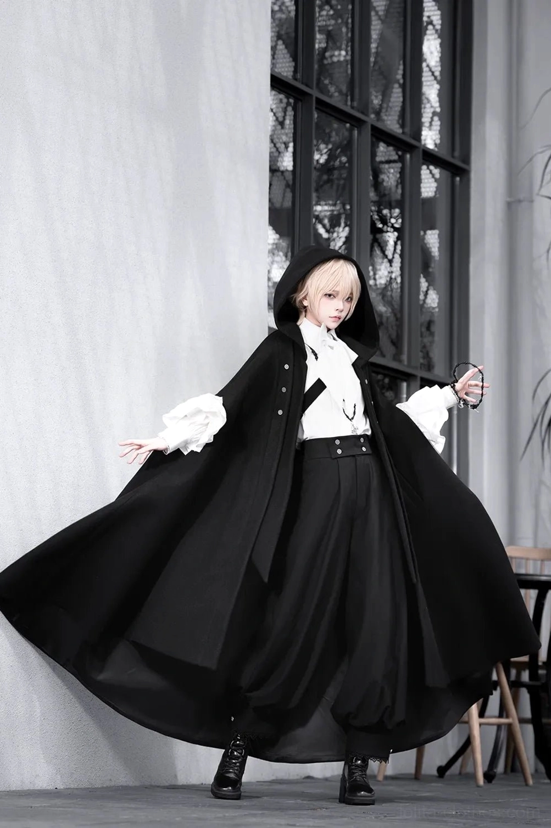 Ouji lolita three-piece set full-body front view worn by blonde model in studio with dramatic black hooded cape blouse and high-waisted pants