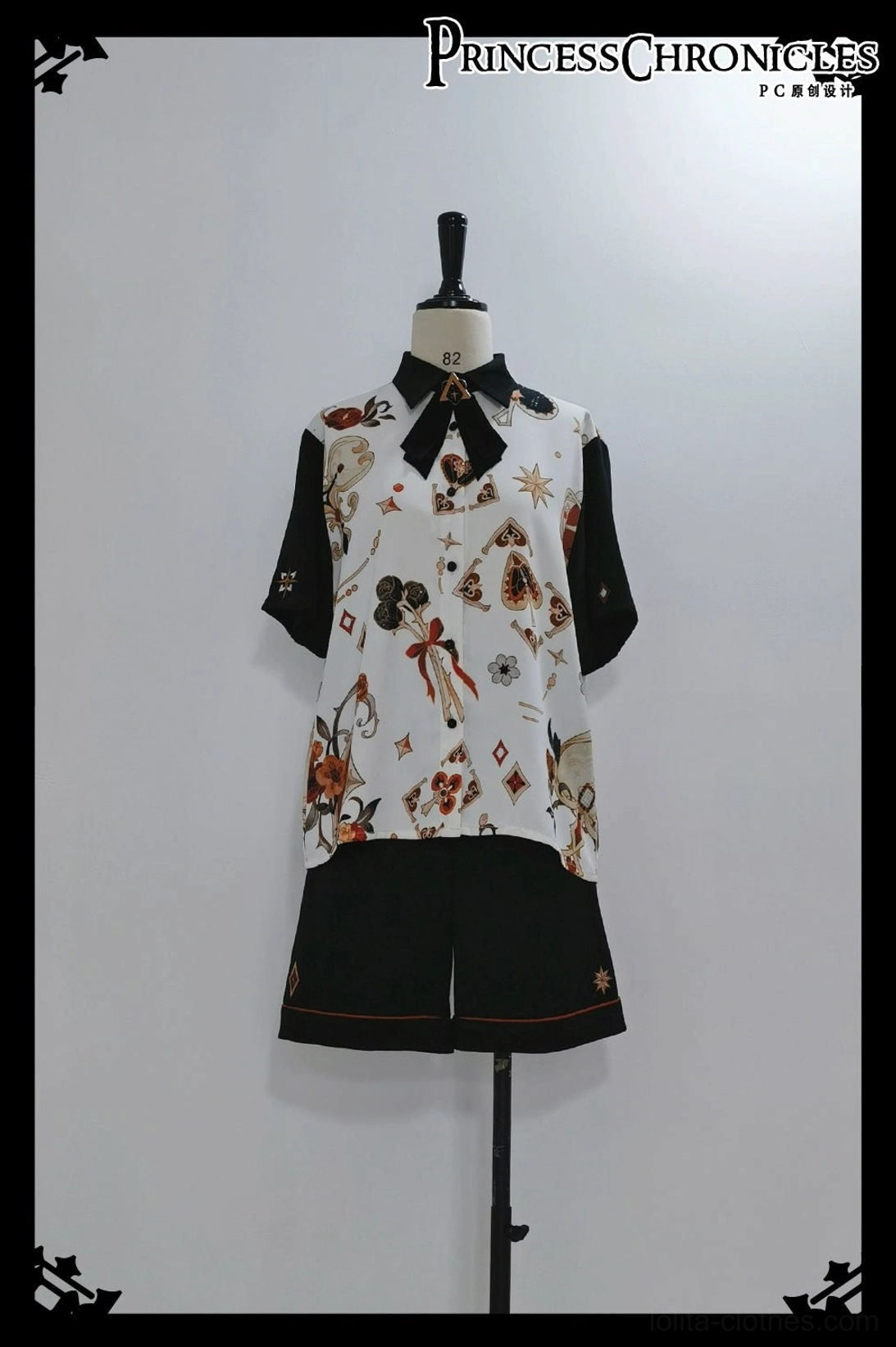 Ouji Lolita floral shirt and embroidered black shorts set on dress form mannequin front full display view, complete outfit with bow tie, white studio background framing