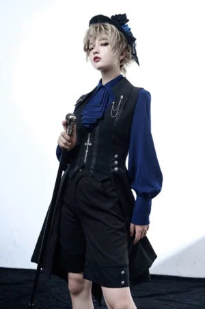 Male lolita ouji aristocrat formal outfit full-body front view with blonde model wearing black vest corset ruffled blue cravat and tailored shorts gothic studio