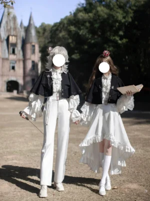 Ouji Lolita princess sleeve blouse with dramatic ruffled sleeves and lace trim paired with high-waist tailored pants cape with metal buttons outdoor castle setting