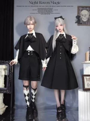 Ouji Lolita Night Raven couple outfit with detachable black capes and jabot scarves, front view of both cosplayers in dark European studio, featuring bow neck accessories and coordinated gothic formal wear