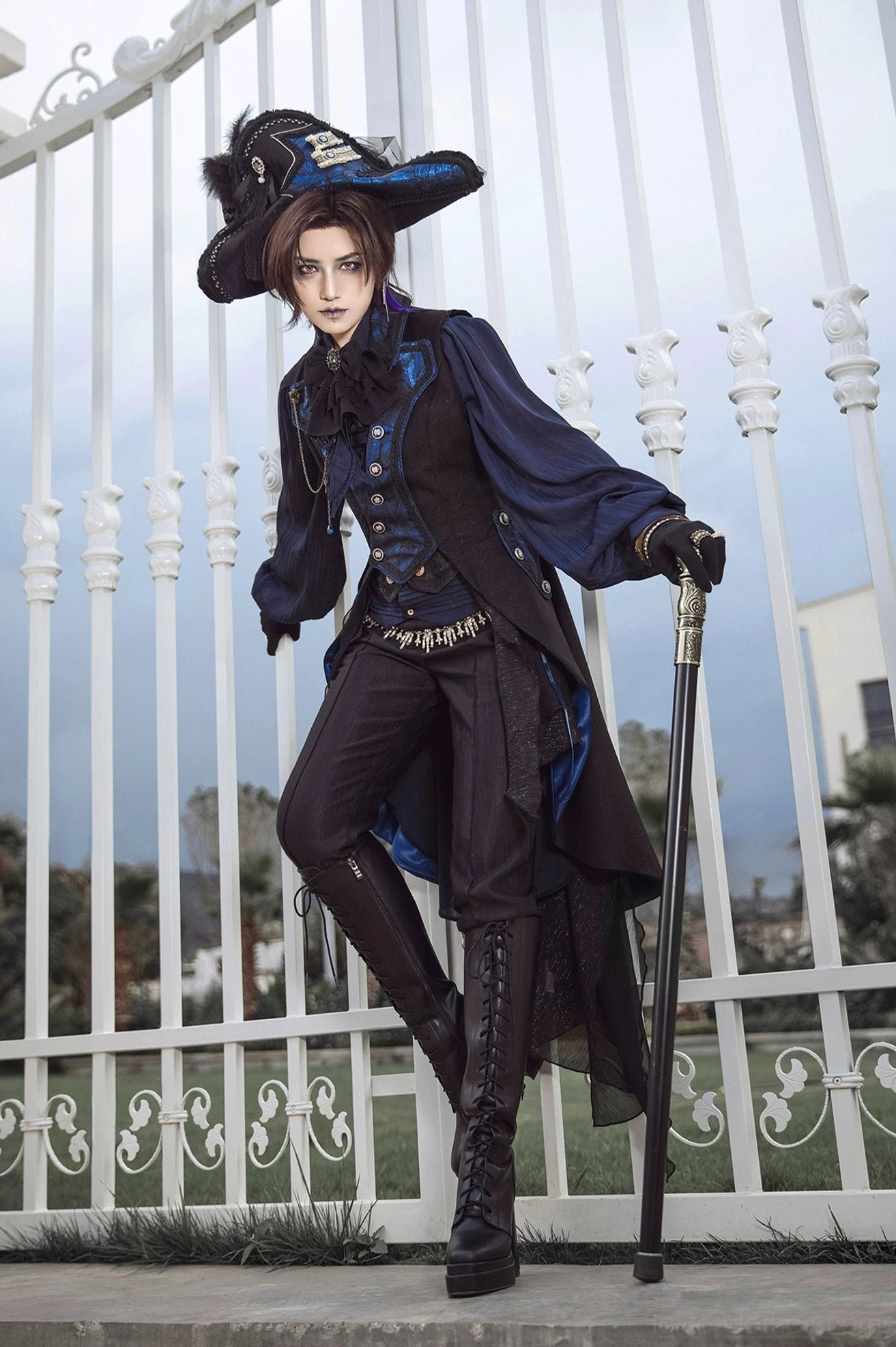 Blue-black gothic Ouji Lolita sleeveless tailcoat dynamic pose outdoor backdrop with high-low tail hem and formal top hat